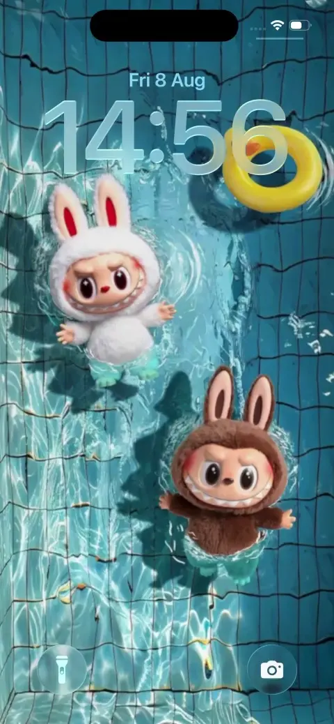 青いプールの水面に浮かぶ、ウサギの着ぐるみを着た白と茶色のラブブのフィギュア。