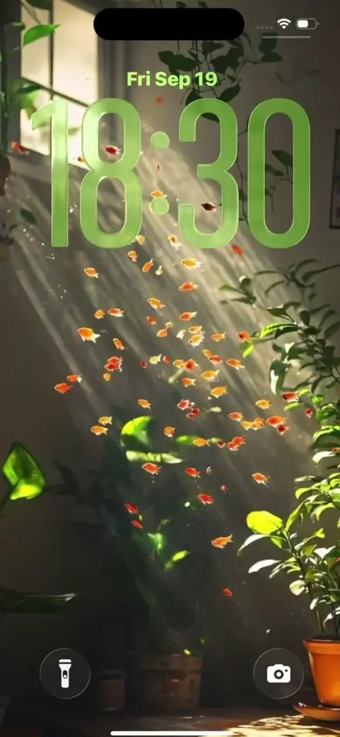 室内に差し込む光の中を泳ぐ無数の金魚と観葉植物の幻想的な風景